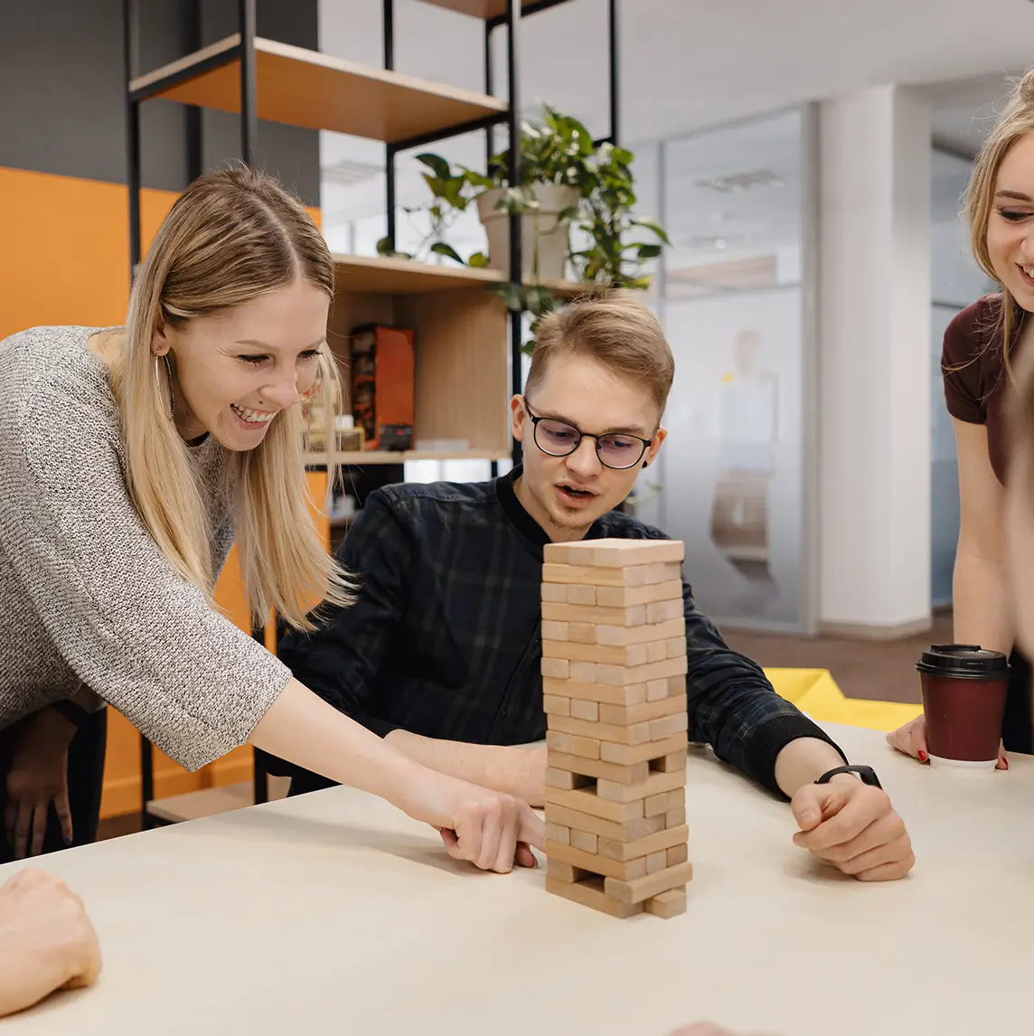 Dos personas construyendo una torre de bloques en una dinámica de equipo